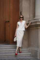 a lady in a white vest and a white hollow dress